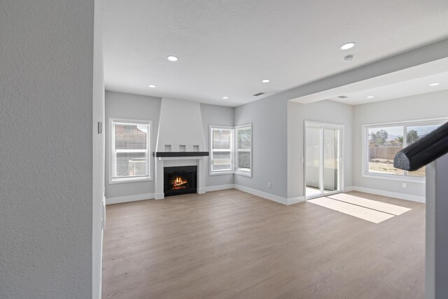 4046 Kona Ct, Palmdale, CA 93552 - unfurnished living room featuring wood finished floors, a warm lit fireplace, and recessed lighting