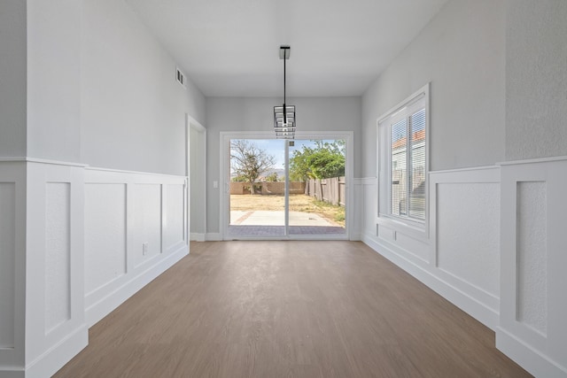 4046 Kona Ct, Palmdale, CA 93552 - unfurnished dining area with wood finished floors, a decorative wall, wainscoting, and a chandelier
