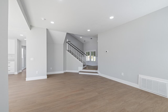 4046 Kona Ct, Palmdale, CA 93552 - unfurnished living room featuring stairs, light wood-type flooring, and recessed lighting