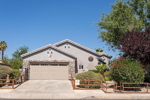 43963 Glenraven Rd, Lancaster, CA 93535 - view of front of property featuring stucco siding, driveway, a garage, a tile roof, and stone siding