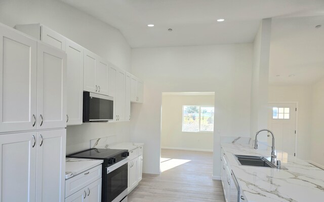 kitchen featuring lofted ceiling, sink, gray cabinets, dishwasher, and a kitchen island with sink