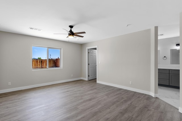 spare room with ceiling fan and light wood-type flooring