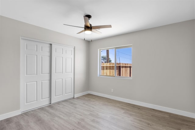 unfurnished bedroom featuring light hardwood / wood-style floors, a closet, and ceiling fan