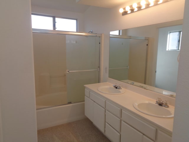 full bath with a wealth of natural light, enclosed tub / shower combo, and a sink