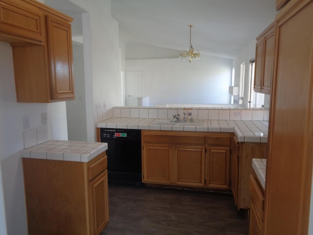 kitchen with tile countertops, a peninsula, a sink, black dishwasher, and decorative light fixtures