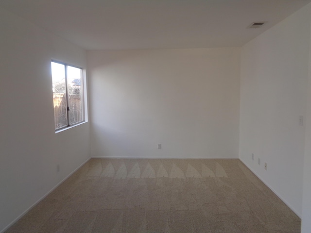 unfurnished room featuring light colored carpet and visible vents