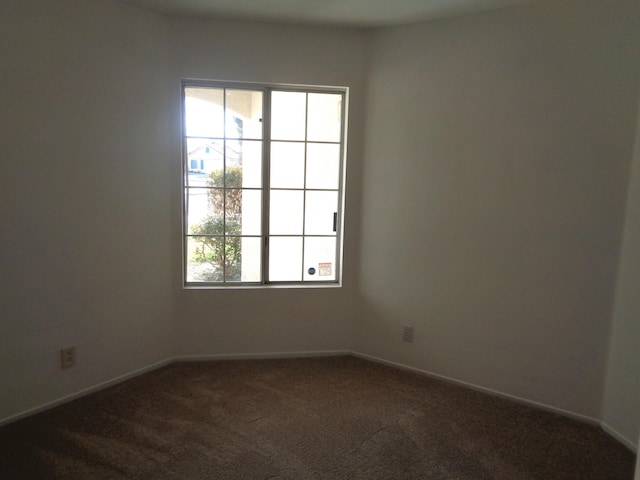 carpeted empty room featuring baseboards