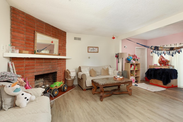 living room featuring hardwood / wood-style floors, a fireplace, and a textured ceiling