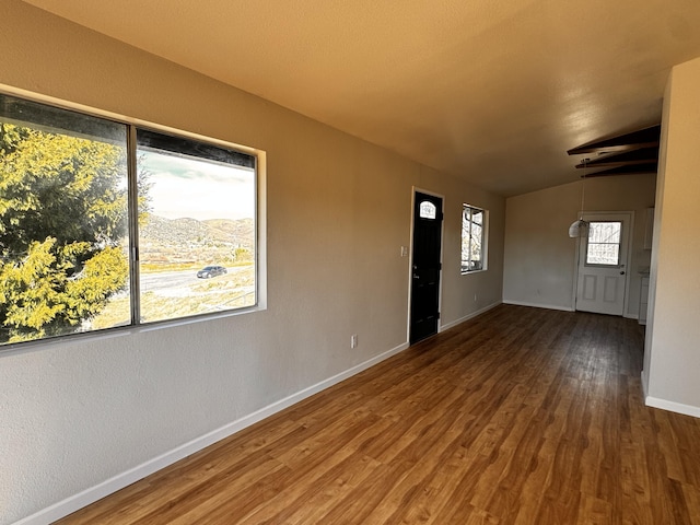 entryway with baseboards, wood finished floors, and lofted ceiling
