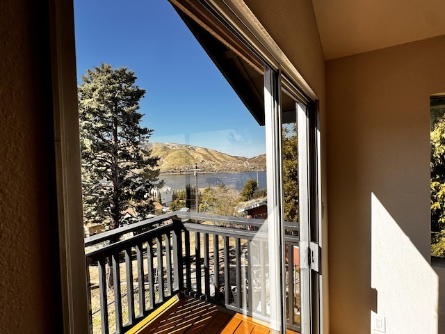 balcony featuring a water and mountain view