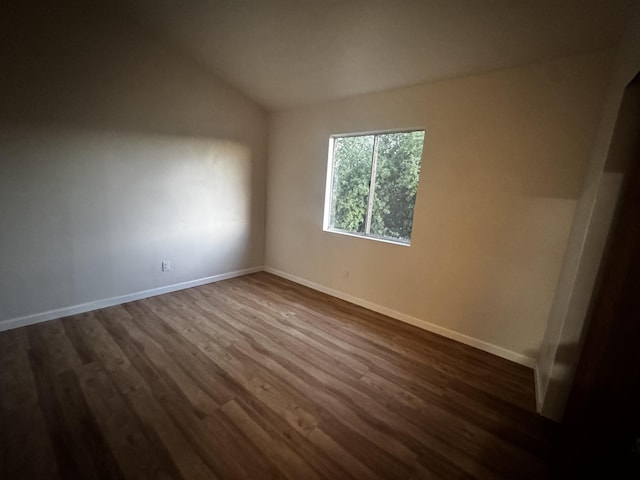 bonus room with dark wood-style flooring, vaulted ceiling, and baseboards
