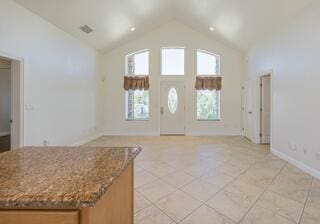 interior space featuring light tile patterned floors and vaulted ceiling