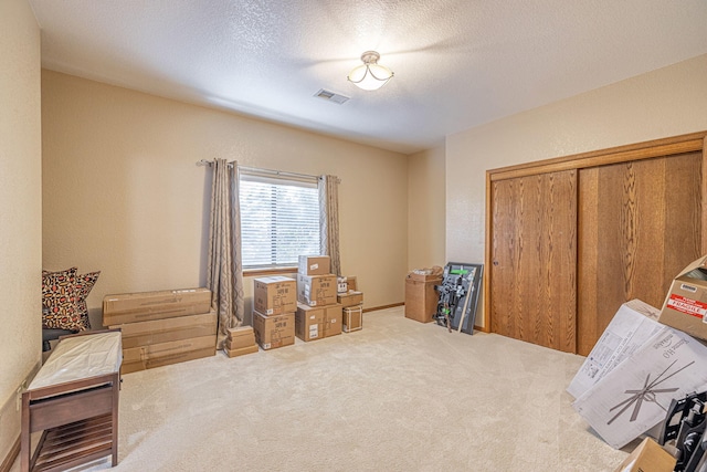 misc room featuring a textured ceiling and carpet floors