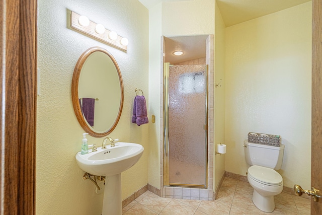 bathroom with tile patterned flooring, toilet, and walk in shower