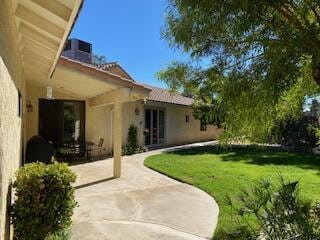 rear view of property featuring a yard and a patio