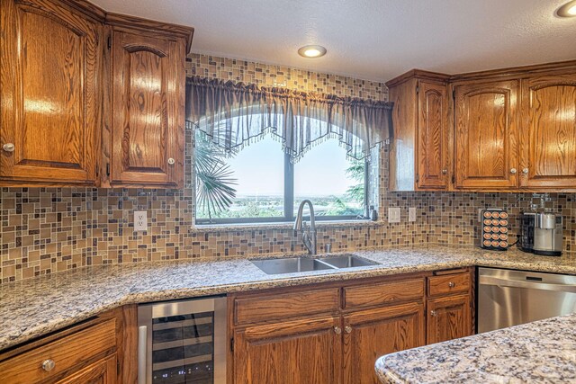 kitchen with tasteful backsplash, light stone counters, sink, dishwasher, and wine cooler