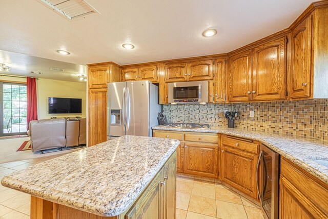 36546 El Camino Dr, Palmdale, CA 93551 - kitchen featuring decorative backsplash, a center island, light stone counters, and appliances with stainless steel finishes
