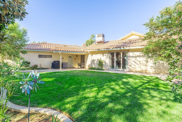 back of property with a yard, a patio, and cooling unit