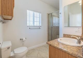 bathroom featuring toilet, vanity, tile patterned floors, and walk in shower