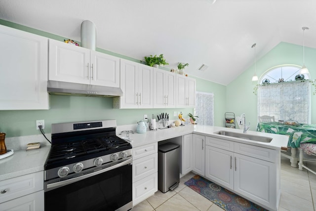 kitchen featuring kitchen peninsula, stainless steel range with gas cooktop, sink, decorative light fixtures, and white cabinetry