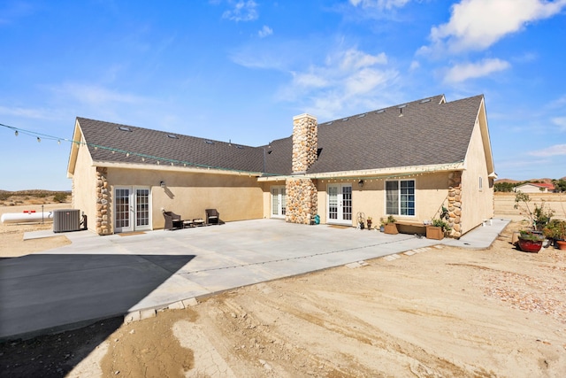 rear view of house with central air condition unit, french doors, and a patio