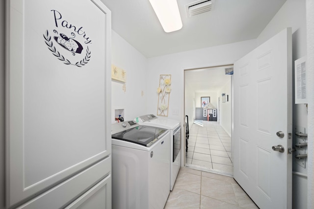 laundry room with light tile patterned floors and washing machine and clothes dryer