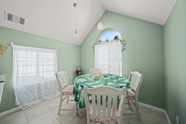 tiled dining room featuring lofted ceiling