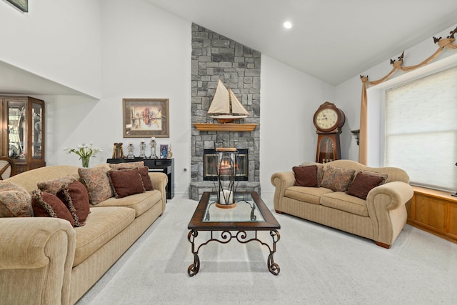 carpeted living room with a stone fireplace and lofted ceiling