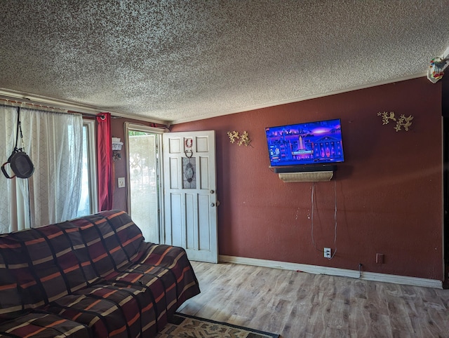 unfurnished living room featuring a textured ceiling, wood-type flooring, and crown molding