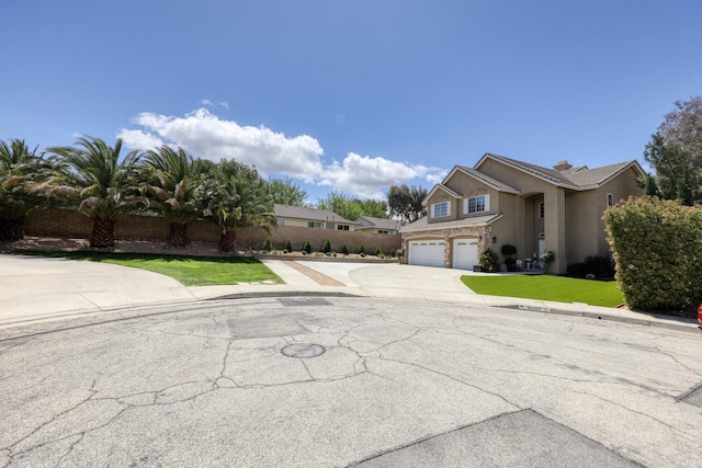 view of front of property with fence, a front lawn, a garage, stucco siding, and driveway