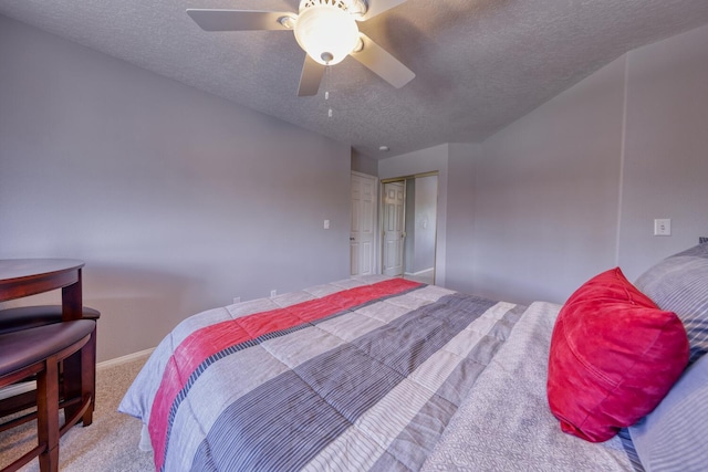 bedroom with carpet floors, a closet, baseboards, ceiling fan, and a textured ceiling