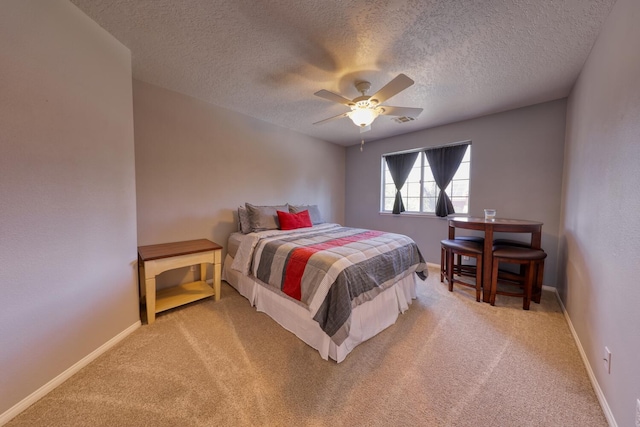 bedroom with baseboards, light carpet, a ceiling fan, and a textured ceiling