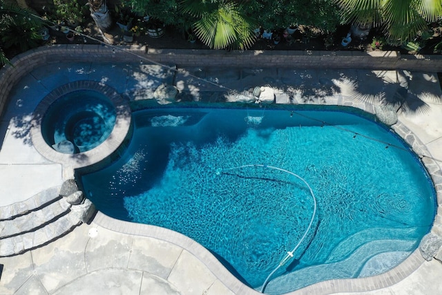 view of swimming pool featuring a pool with connected hot tub