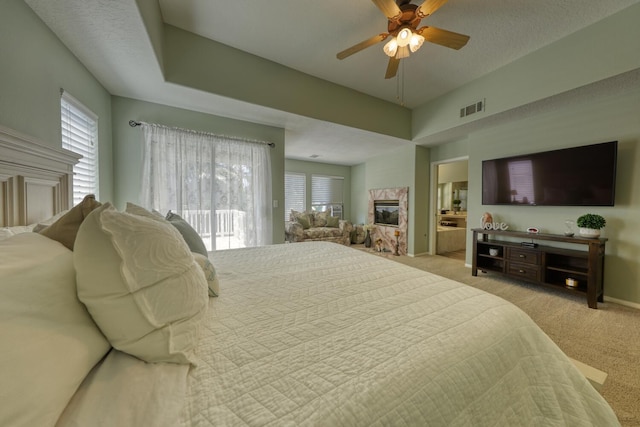 bedroom featuring visible vents, access to exterior, light colored carpet, a ceiling fan, and a multi sided fireplace