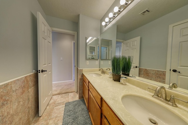 full bathroom with a sink, double vanity, and visible vents