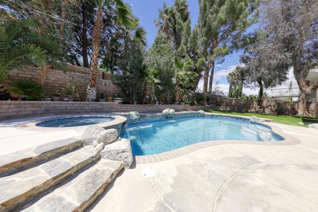 view of pool featuring a pool with connected hot tub, a fenced backyard, and a patio area