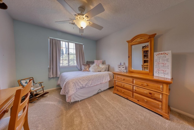 carpeted bedroom featuring baseboards, a textured ceiling, and ceiling fan