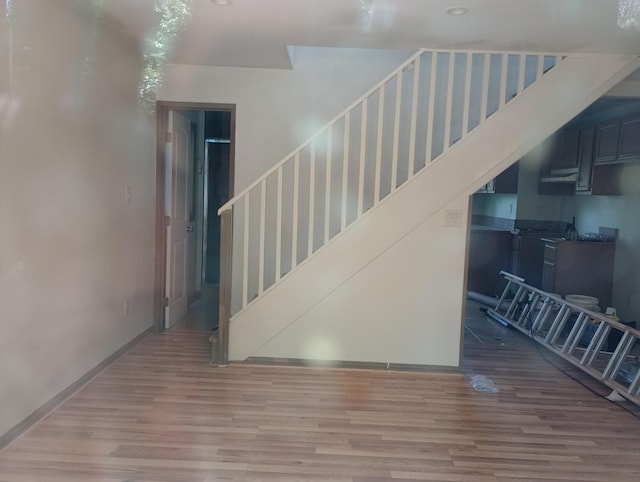 stairway with baseboards and wood finished floors
