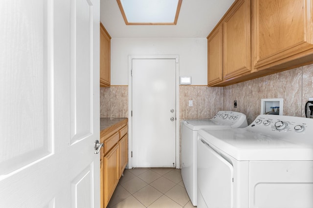 washroom featuring light tile patterned floors, washer and dryer, and cabinet space