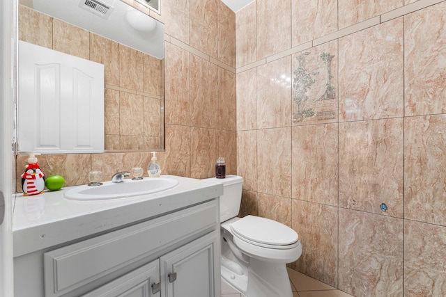 half bath featuring visible vents, toilet, tile walls, tile patterned flooring, and vanity