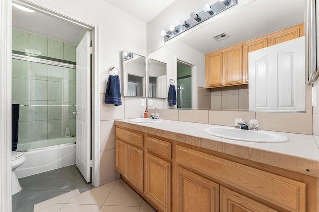 full bath featuring tile patterned floors, visible vents, double vanity, and a sink