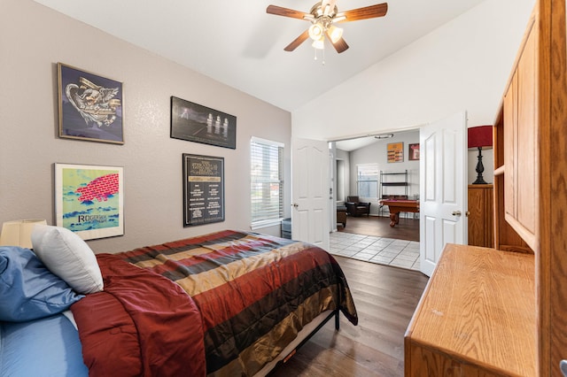 bedroom with a ceiling fan, vaulted ceiling, and wood finished floors