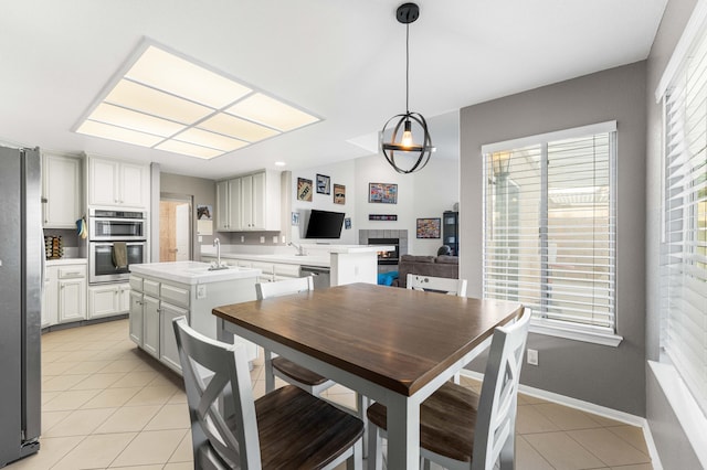 dining space featuring light tile patterned flooring and baseboards