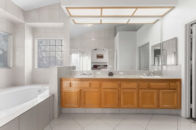 bathroom with a sink, a bath, double vanity, and vaulted ceiling