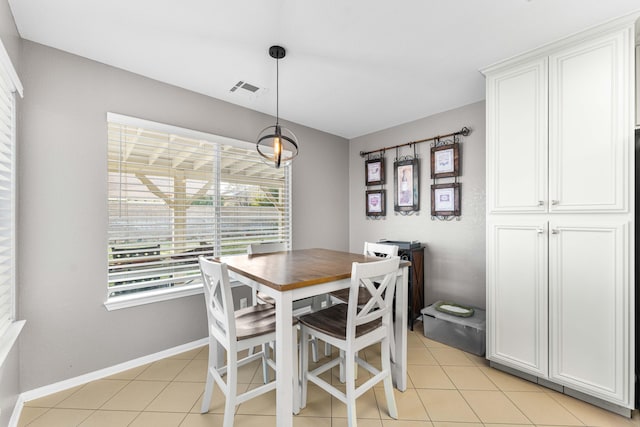 dining space featuring light tile patterned floors, visible vents, and baseboards