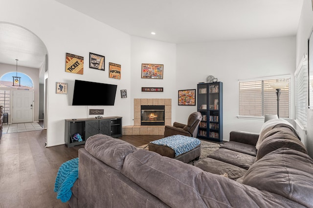 living area with arched walkways, recessed lighting, a fireplace, and wood finished floors