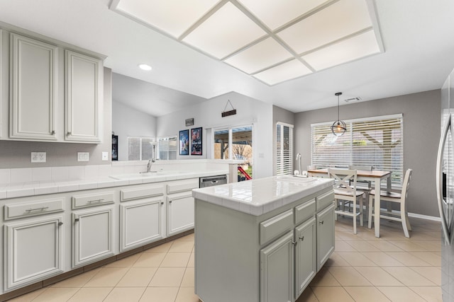 kitchen featuring tile counters, light tile patterned flooring, visible vents, and a sink