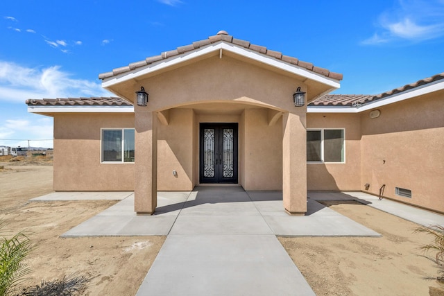 2929 W 28th St, Rosamond, CA 93560 - entrance to property featuring french doors, stucco siding, a tiled roof, and a patio
