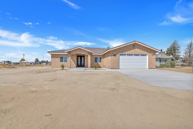 2929 W 28th St, Rosamond, CA 93560 - single story home with stucco siding, a garage, french doors, a tile roof, and driveway