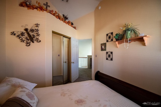 carpeted bedroom featuring lofted ceiling, a closet, and visible vents